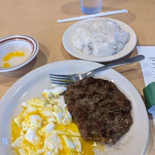 Two poached eggs one patty of sausage one serving of biscuits and gravy
