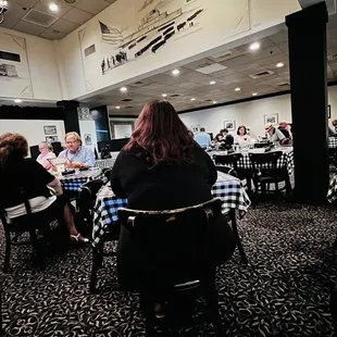 people sitting at tables in a restaurant