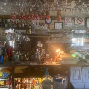 a bar with wine glasses hanging from the ceiling