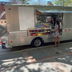 a woman standing in front of a food truck