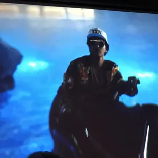 a man on a motorbike in front of a large screen