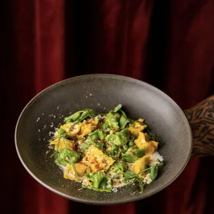 Sweet Corn and Pea Agnolotti - handcrafted pasta pockets filled with roasted corn and pea truffle ricotta, topped with seasonal truffle.