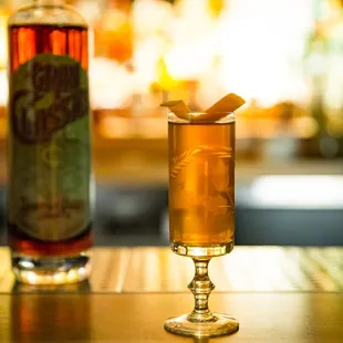 a glass of alcohol and a bottle of liquor