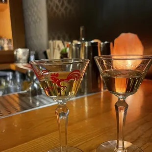 two martini glasses on a bar