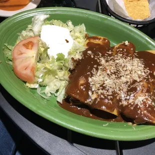 a plate of enchiladas and a salad