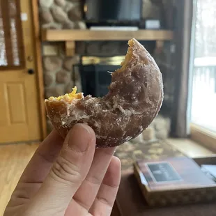 a hand holding a half eaten donut