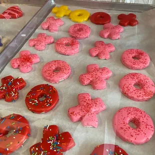 a tray of pink donuts with sprinkles