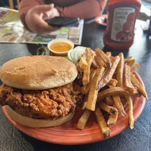 The mother cluckin sandwich fries with nacho cheese on the side and a grilled jalapeño