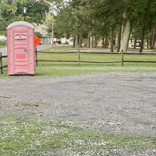Gravel parking lot dedicated to the playground and a portable toilet