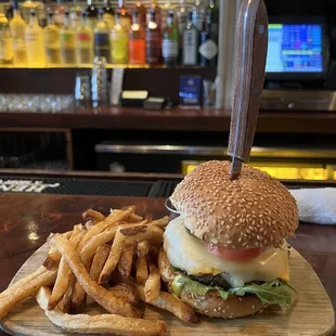 a burger and french fries on a cutting board