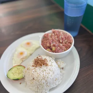 a plate of rice, beans, cucumber, and an egg