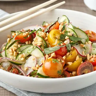 a bowl of salad with chopsticks