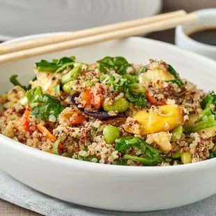 a bowl of food with chopsticks