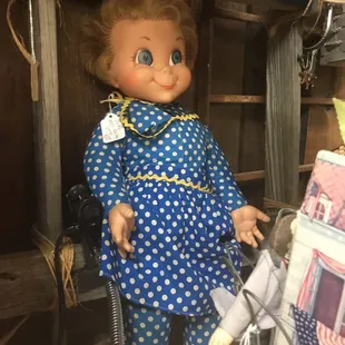 a doll wearing a blue polka dot dress