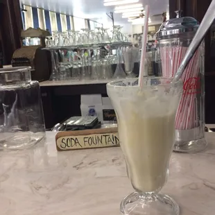 a glass of milkshake on a table