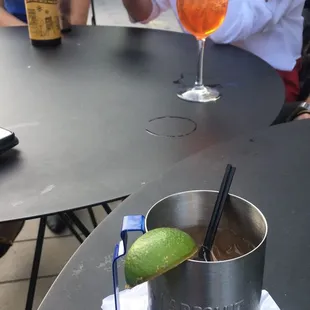 a drink in a metal cup with a lime wedge