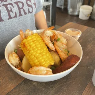a bowl of shrimp, corn and potatoes