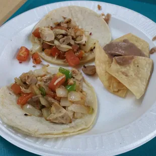 Love how they serve the tacos with a side of beans and chips yummy