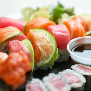 a plate of sushi with a dipping sauce