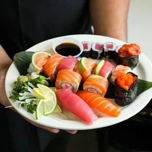 a person holding a plate of sushi