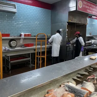 workers preparing fish in a commercial kitchen