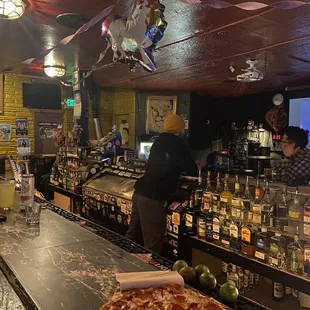 a bar with a pizza on the counter