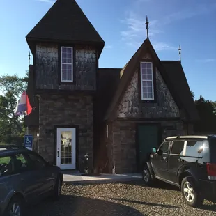 two cars parked in front of a stone building