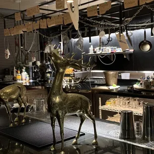 a bar with a deer statue in the foreground