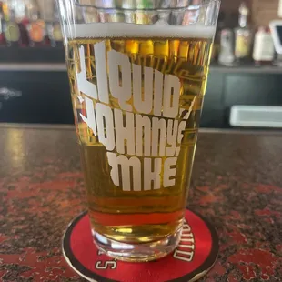 a glass of liquid on a coaster
