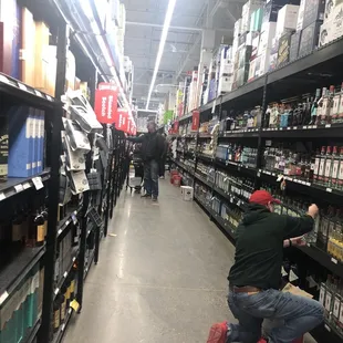 a man kneeling on the floor in a store aisle