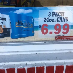 three cans of corona extra on display in a store window