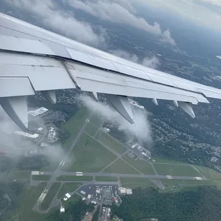 the wing of an airplane flying over a city