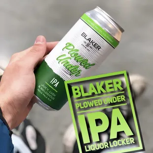 a person holding a can of beer