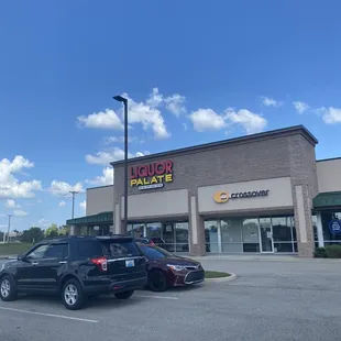 two cars parked in front of a liquor palate