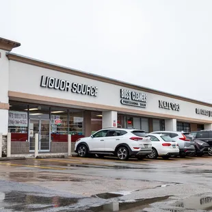 a row of parked cars in front of a liquor store