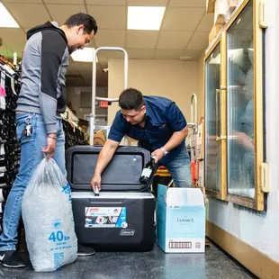 two men looking at a cooler in a store