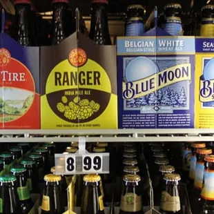 a variety of beer bottles in a refrigerator