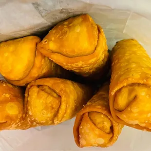 a pile of pastries wrapped in wax paper
