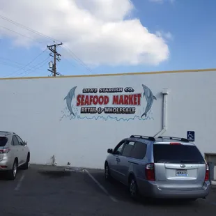 two cars parked in front of a seafood market