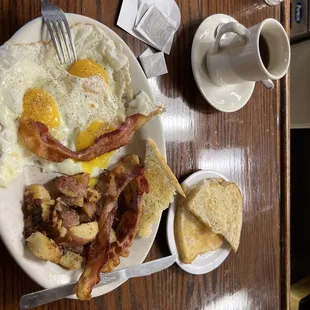 Three sunny side up with home fries and bacon