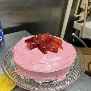 a pink cake with strawberries on top