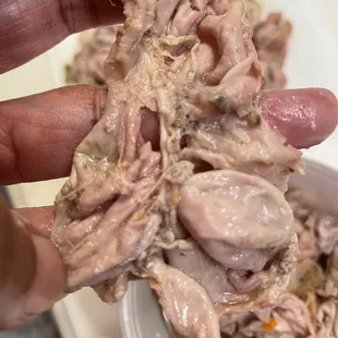 a person's hand holding a piece of meat