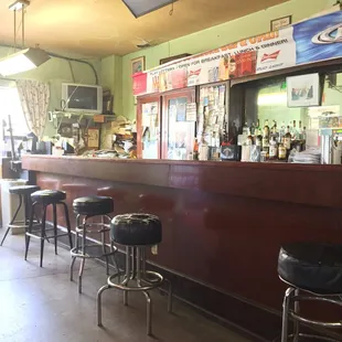 Older bar with worn bar stools has character.