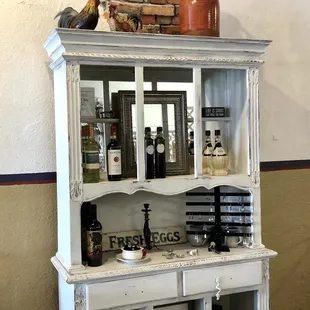 a display cabinet with wine bottles on top