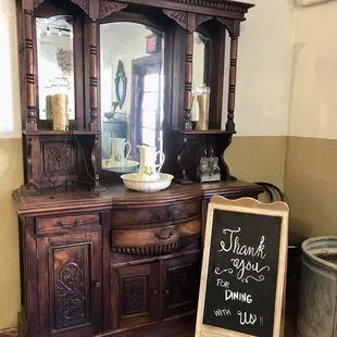 a wooden hutch with a chalkboard sign