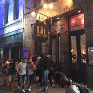 a group of people standing outside a bar