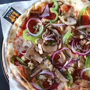 a pizza with pepperoni, mushrooms, onions, and cheese