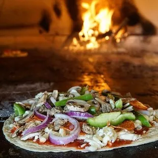 a pizza being cooked in a brick oven