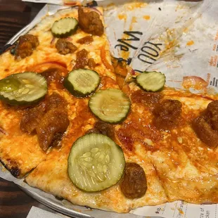 a slice of pizza with pickles on it