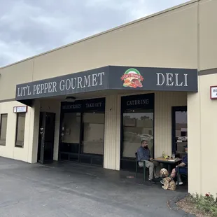 people sitting outside a deli